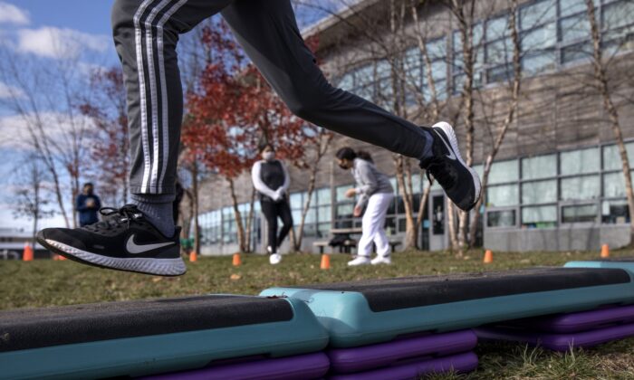 Estudiantes de séptimo grado corren a través de una carrera de obstáculos mientras hacen ejercicio al aire libre, en la Escuela Internacional Rogers, en Stamford, Connecticut, el 24 de noviembre de 2020. (John Moore/Getty Images)