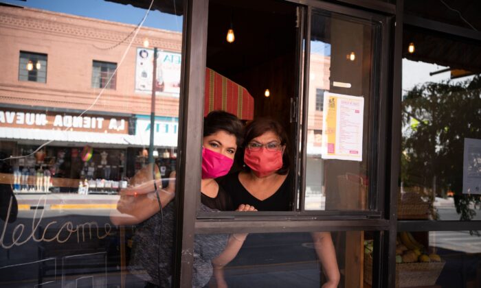 Vanessa Zubia-Meza y su madre Margie Zubia en el escaparate de su nuevo restaurante llamado El Paseo, en el centro de El Paso, Texas, el 18 de mayo de 2020. (Paul Ratje/AFP vía Getty Images)