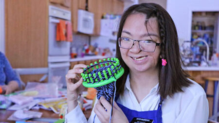 Mujer de 23 años que nació con discapacidades teje sombreros para ayudar bebés prematuros