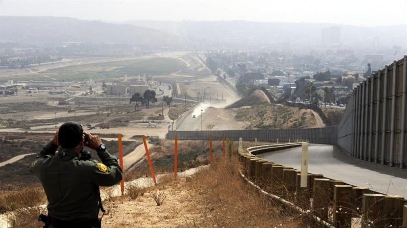 Un oficial de la Patrulla Estadounidense de Frontera observa a través de sus binoculares hacia Tijuana, México, desde la frontera entre Estados Unidos y México en el Valle del Río Tijuana, California (EE.UU.). EFE/Mike Nelson/Archivo