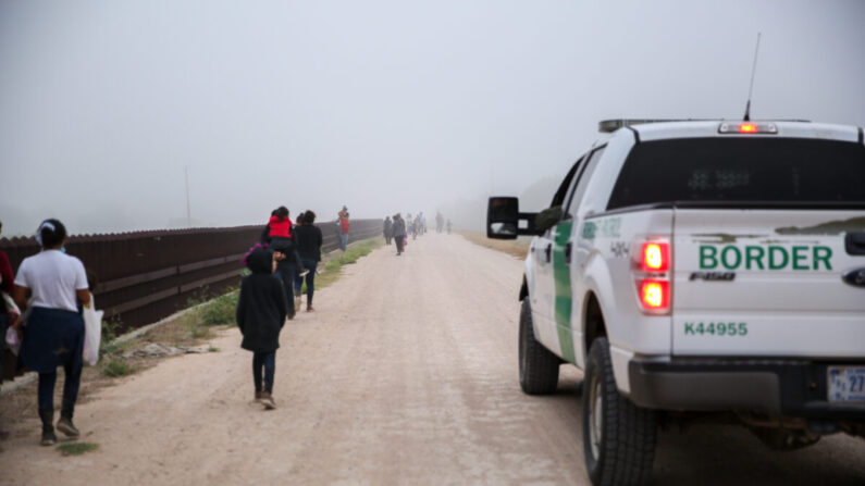 Un grupo de inmigrantes ilegales con la Patrulla Fronteriza después de cruzar la frontera entre Estados Unidos y México en La Joya, Texas, el 10 de abril de 2021. (Charlotte Cuthbertson/The Epoch Times)