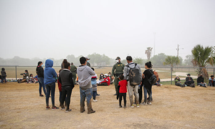 Un grupo de inmigrantes ilegales se reúne con la Patrulla Fronteriza después de cruzar la frontera entre Estados Unidos y México en La Joya, Texas, el 10 de abril de 2021. (Charlotte Cuthbertson/The Epoch Times)