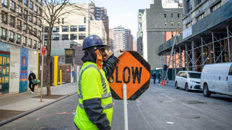 Un trabajador de la construcción sostiene una señal de tráfico en Manhattan, Nueva York, el 20 de noviembre de 2020. (Samira Bouaou/The Epoch Times)
