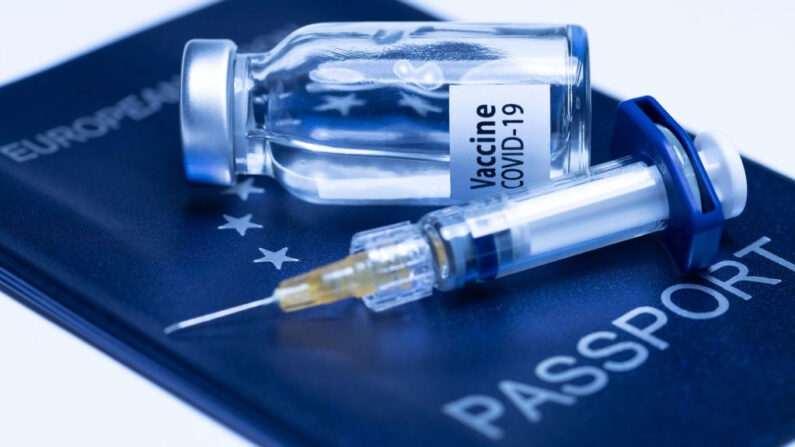 Una fotografía tomada el 3 de marzo de 2021 en París, Francia, muestra un frasco de vacuna que dice "Vacuna contra Covid-19" y una jeringa en un pasaporte europeo. (Joel Saget / AFP vía Getty Images)