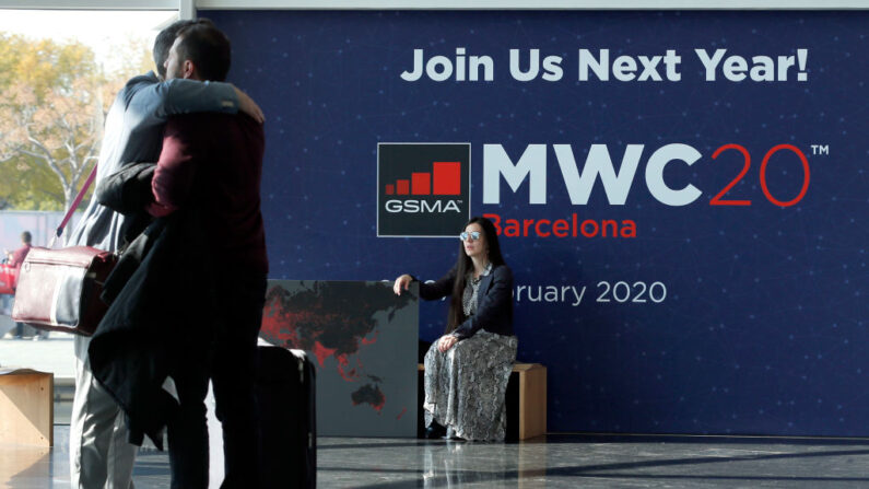 Una mujer mira a dos visitantes abrazándose el último día del Mobile World Congress (MWC) en Barcelona (España) el 28 de febrero de 2019. (Pau Barrena / AFP vía Getty Images)