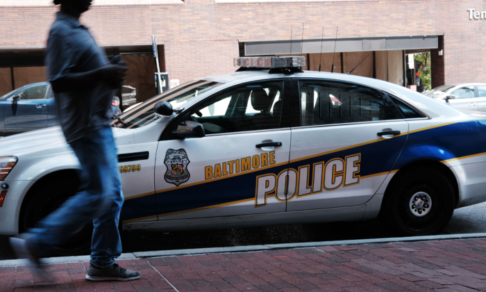 Una persona pasa junto a un coche de policía el 28 de julio de 2019, en Baltimore, Maryland. (Spencer Platt/Getty Images)