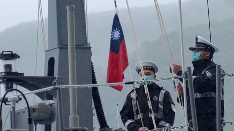 Dos soldados de la armada taiwanesa izan la bandera nacional en la primera lancha rápida nacional de colocación de minas durante una ceremonia oficial en un astillero en Suao, en el condado de Yilan, al este de Taiwán, el 15 de diciembre de 2020. (Sam Yeh / AFP vía Getty Images)