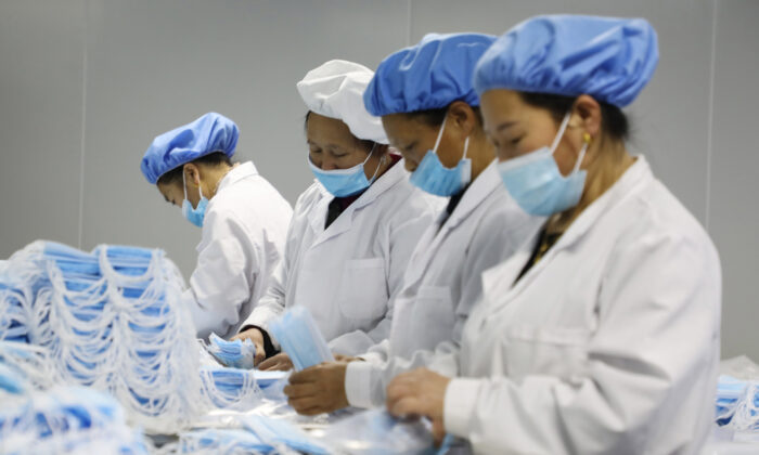 Trabajadores elaborando mascarillas médicas en una fábrica en Jishou, provincia de Hunan, China, el 28 de enero de 2021. (STR/AFP vía Getty Images)