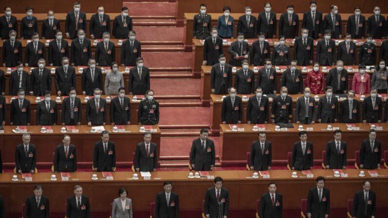 El mandatario chino Xi Jinping (centro) y los legisladores se ponen de pie para el himno durante la sesión de clausura de la conferencia de la legislatura títere en el Gran Salón del Pueblo en Beijing, China, el 11 de marzo de 2021. (Kevin Frayer/Getty Images)