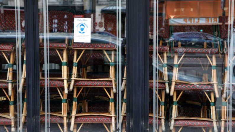 Las sillas se apilan dentro de una famosa cafetería cerrado junto con todos los cafés y restaurantes para frenar la propagación del covid-19 en el distrito de Saint-Germain-des-Prés de París, Francia, el 15 de marzo de 2021. (Ludovic Marin / AFP vía Getty Images)