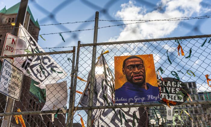 Un cartel con la foto de George Floyd y un letrero dice que "No puedo respirar" cuelgan de una valla de seguridad fuera del Centro de Gobierno del Condado de Hennepin en Minneapolis, el 31 de marzo de 2021 (Kerem Yucel / AFP a través de Getty Images).