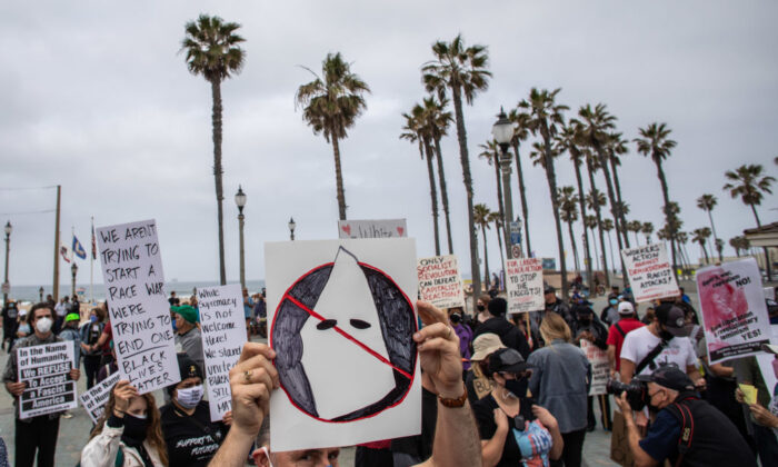 Un hombre sostiene un cartel anti-KKK durante una protesta contra la supremacía blanca en Huntington Beach, California, el 11 de abril de 2021. (Apu Gomes/Getty Images)