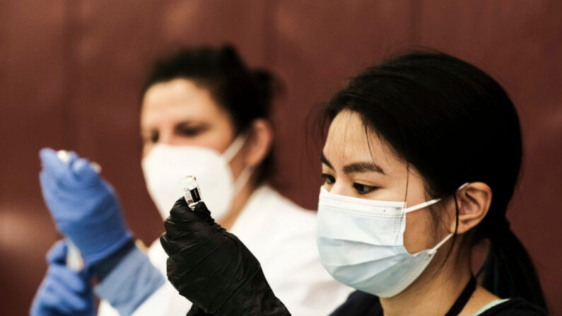 Una farmacéutica voluntaria prepara dosis de la vacuna contra COVID-19 de Johnson & Johnson durante una clínica emergente en la Western International High School el 12 de abril de 2021 en Detroit, Michigan (EE.UU.). (Matthew Hatcher/Getty Images)