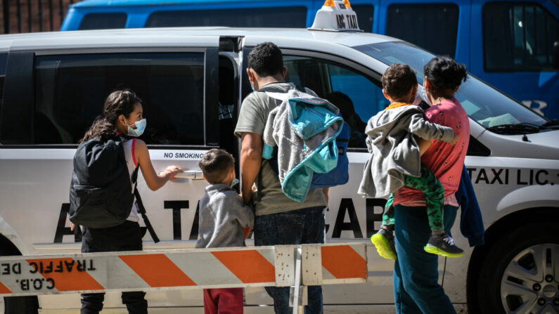 Un grupo familiar de solicitantes de asilo toma un taxi al aeropuerto para continuar su viaje dentro de los Estados Unidos después de ser liberados por las autoridades de inmigración en Brownsville, Texas, el 24 de febrero de 2021. (John Moore/Getty Images)