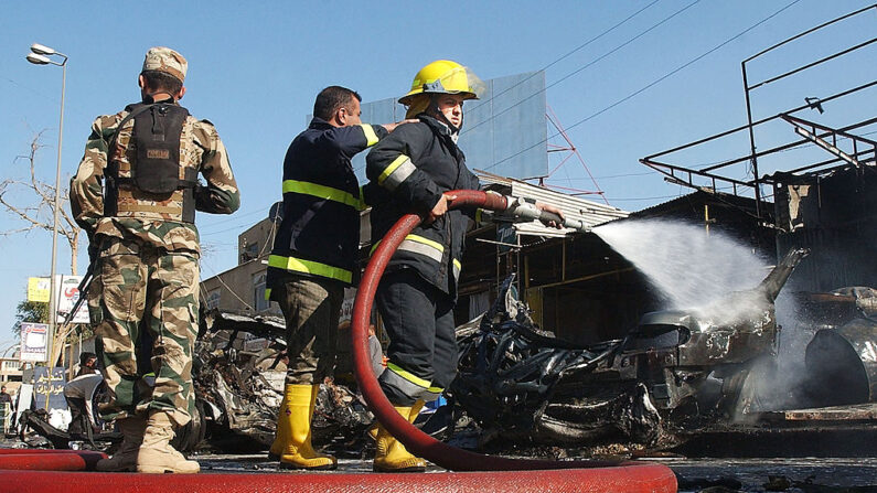 Bomberos iraquíes apagaron el fuego en el sitio de la explosión de un coche bomba el 26 de diciembre de 2005 en Bagdad, Irak. (Wathiq Khuzaie / Getty Images)