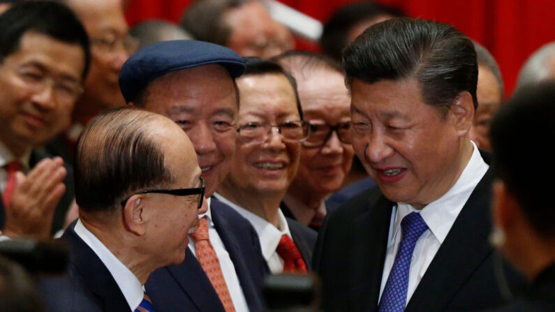 El presidente de China, Xi Jinping (D), es saludado por el magnate hongkonés Li Ka-shing (I) antes de una sesión fotográfica durante la visita de Xi a Hong Kong el 30 de junio de 2017. (BOBBY YIP/AFP vía Getty Images)