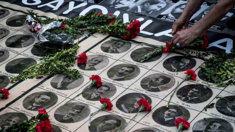 Una mujer coloca rosas sobre los retratos de las víctimas durante un memorial para conmemorar los asesinatos masivos de armenios de 1915 el 24 de abril de 2018 en Estambul, Turquía. (Chris McGrath/Getty Images)