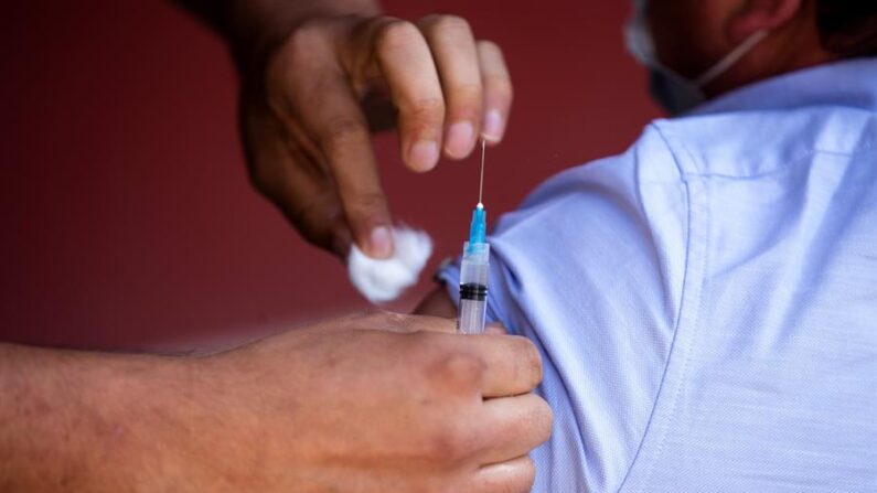 Un hombre recibe una dosis de la vacuna china Sinovac contra la covid-19 en un centro de vacunación de Santiago (Chile). EFE/Alberto Valdés