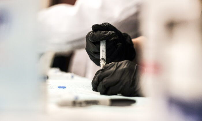 Un farmacéutico voluntario prepara dosis de la vacuna anti-COVID de Johnson & Johnson, en una clínica en Detroit, Michigan, el 12 de abril de 2021. (Matthew Hatcher/Getty Images)