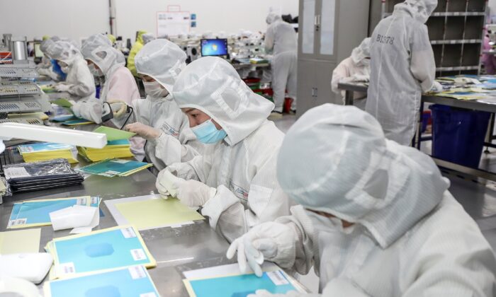 Un grupo de trabajadores produce chips LED en una fábrica de la ciudad de Huaian, en la provincia oriental china de Jiangsu, el 16 de junio de 2020. (STR/AFP vía Getty Images)