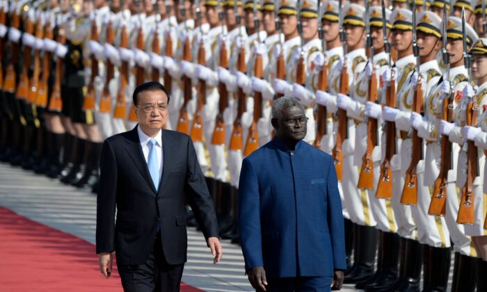 El primer ministro de las Islas Salomón, Manasseh Sogavare (dcha.), y el primer ministro chino, Li Keqiang, pasan revista a la guardia de honor durante una ceremonia de bienvenida en el Gran Salón del Pueblo en Beijing el 9 de octubre de 2019. (Wang Zhao/AFP vía Getty Images)