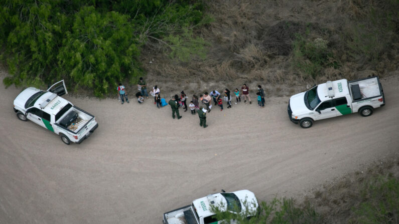 Agentes de la Patrulla Fronteriza de Estados Unidos ponen bajo custodia a inmigrantes ilegales, vistos desde un helicóptero del Departamento de Seguridad Pública de Texas, cerca de la frontera entre Estados Unidos y México en McAllen, Texas, el 23 de marzo de 2021. (John Moore/Getty Images)
