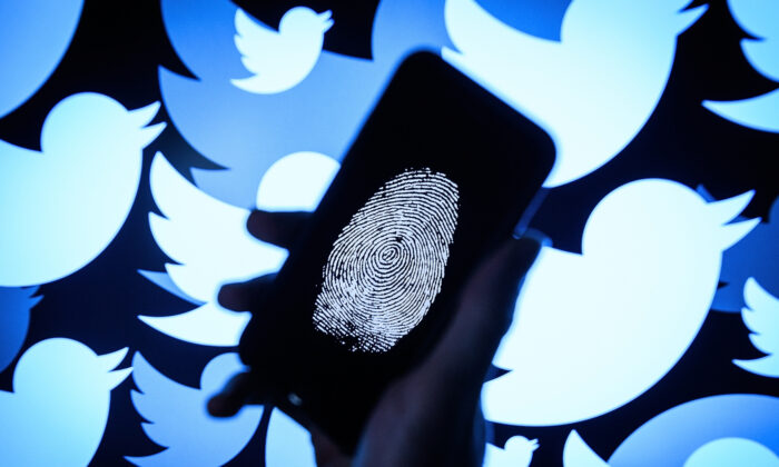 Una huella del pulgar aparece en un teléfono móvil delante del logotipo de la red social Twitter proyectado en una pantalla en Londres, Inglaterra, el 9 de agosto de 2017. (Leon Neal/Getty Images)