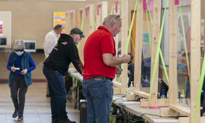 Las personas se registran para votar en un lugar de votación en Sun Prairie, Wisconsin, el 7 de abril de 2020. (Andy Manis/Getty Images)