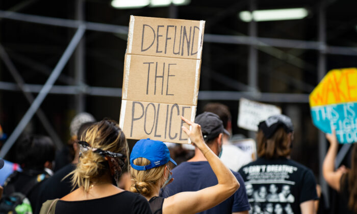 Manifestante sostiene un cartel de "desfinanciar a la policía" en una protesta de Black Lives Matter en Manhattan, Nueva York, el 13 de julio de 2020. Imagen de archivo. (Chung I Ho/archivo/The Epoch Times)