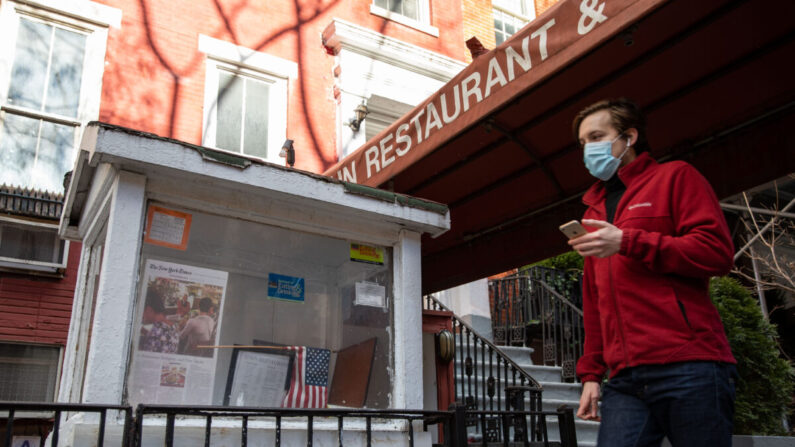 Un hombre con una mascarilla durante la pandemia del virus del PCCh pasa por delante de un restaurante cerrado en Nueva York el 20 de enero de 2021. (Chung I Ho/The Epoch Times)