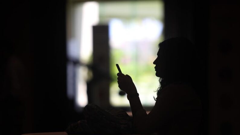 Una joven mira la pantalla de su teléfono celular en medio de un apagón. EFE/ Alonso Cupul / Archivo