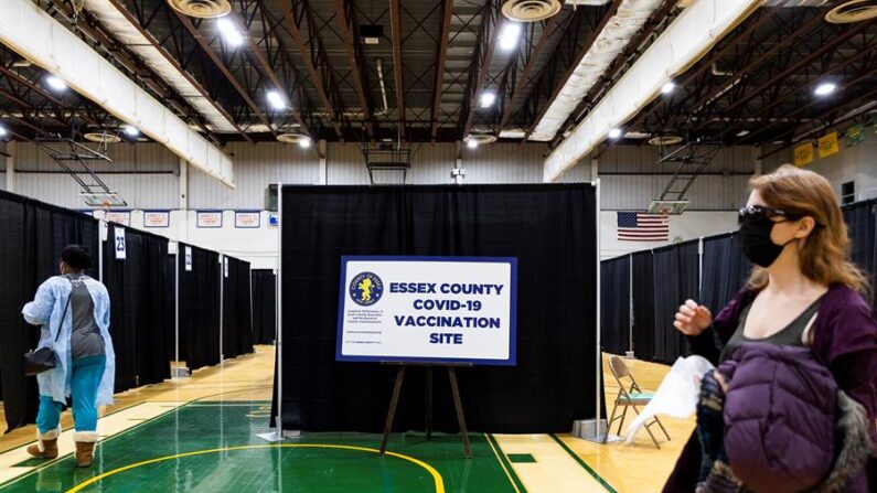 Personas caminan en un sitio de vacunación covid-19 en el gimnasio de Essex County College en Newark, Nueva Jersey, el 3 de febrero de 2021. EFE/EPA/JUSTIN LANE/Archivo