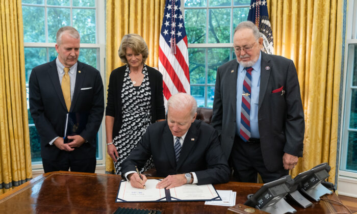 Los senadores Dan Sullivan (R-Alaska) y Lisa Murkowski (R-Alaska), y el representante Don Young (R-Alaska) miran mientras el presidente Joe Biden firma la Ley de Restauración del Turismo en Alaska, en el Despacho Oval de la Casa Blanca, en Washington, el 24 de mayo de 2021. (Foto oficial de la Casa Blanca por Adam Schultz)