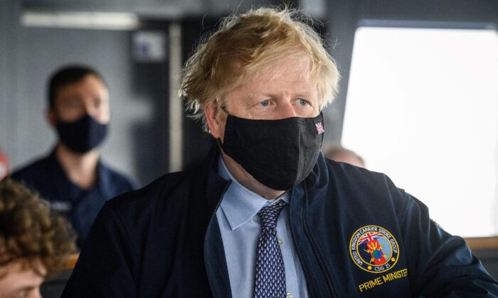 El primer ministro británico, Boris Johnson, lleva una chaqueta bordada en la que se puede leer, Primer Ministro, mientras recorre el portaaviones HMS Queen Elizabeth antes de su salida hacia Asia en su primer despliegue operativo en Portsmouth, suroeste de Inglaterra, el 21 de mayo de 2021. (Leon Neal/Pool/AFP a través de Getty Images)