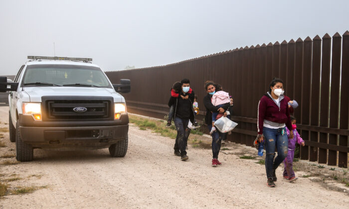 Un grupo de inmigrantes ilegales con la Patrulla Fronteriza luego de cruzar la frontera entre Estados Unidos y México en La Joya, Texas, el 10 de abril de 2021. (Charlotte Cuthbertson/The Epoch Times)