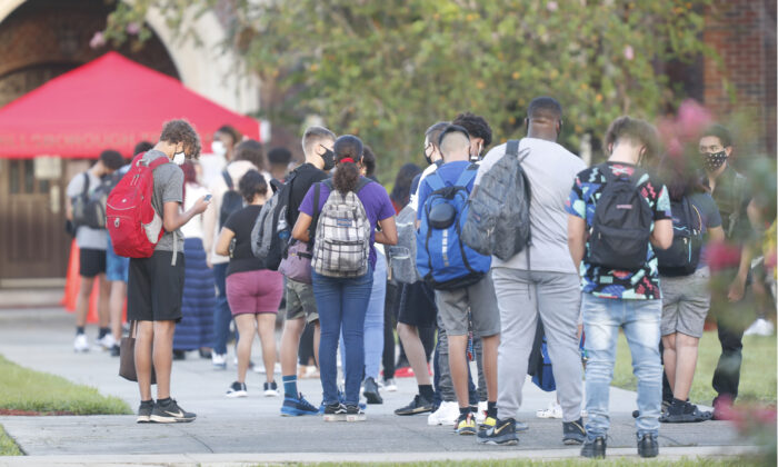 Los estudiantes de la escuela secundaria de Hillsborough esperan en la fila para una revisión de temperatura antes de ingresar al edificio, en Tampa, Florida, el 31 de agosto de 2020. (Octavio Jones/Getty Images)