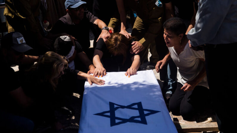 Familiares y amigos lloran durante el funeral del sargento primero Omer Tabib el 13 de mayo de 2021 en Elyakim, Israel. Tabib murió y otros tres soldados resultaron heridos cuando un misil guiado antitanque disparó hacia el sur de Israel desde la Franja de Gaza, impactando en un vehículo del ejército. (Amir Levy/Getty Images)