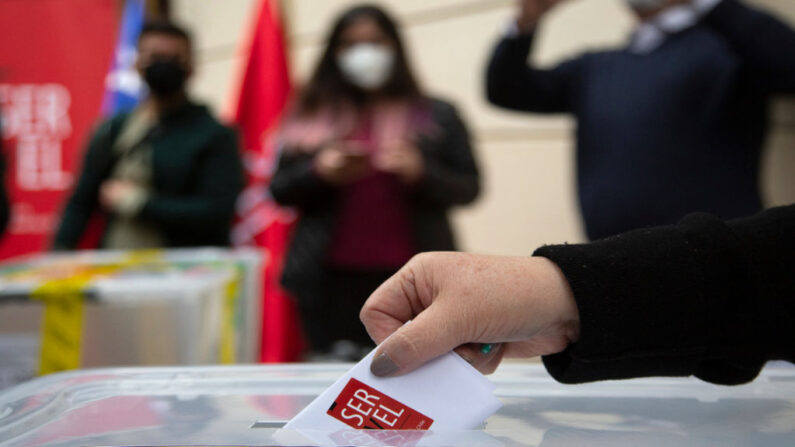 Un trabajador del servicio electoral muestra una papeleta sellada en Santiago (Chile), el 13 de marzo de 2021, antes de las elecciones del 15 y 16 de mayo para elegir alcaldes, concejales y una comisión para reescribir la constitución. (Claudio Reyes/AFP vía Getty Images)