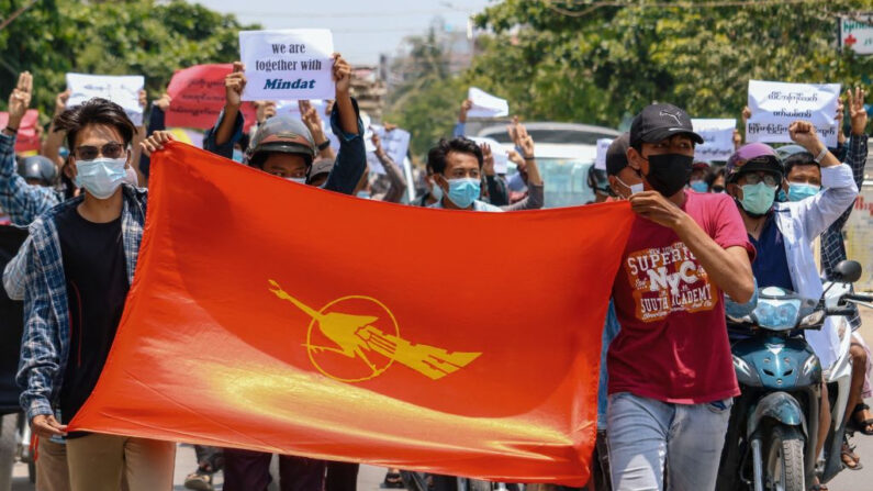 Manifestantes sostienen la bandera de la Unión de Estudiantes de Birmania durante una manifestación contra el golpe militar en Mandalay (Birmania) el 17 de mayo de 2021. (STR/AFP vía Getty Images)