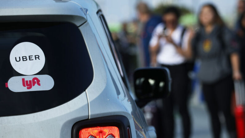 Los pasajeros que llegan esperan para abordar los vehículos Uber en el nuevo lote de recolección de pasajeros de ride-hail 'LAX-it' en el Aeropuerto Internacional de Los Ángeles (LAX) el 6 de noviembre de 2019 en Los Ángeles, California. (Mario Tama/Getty Images)