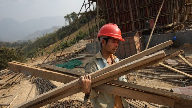 Un trabajador chino lleva materiales para un proyecto de la Iniciativa de la Franja y la Ruta, de un billón de dólares, del PCCh, en Laos, el 8 de febrero de 2020. (Aidan Jones/AFP vía Getty Images)
