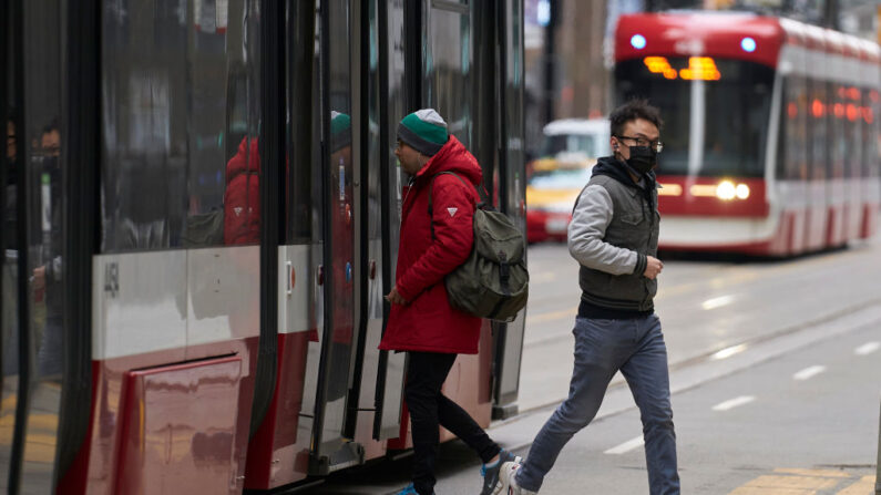 Un hombre con mascarilla se baja de un tranvía en el centro de Toronto, Ontario, el 24 de marzo de 2020. (GEOFF ROBINS/AFP vía Getty Images)
