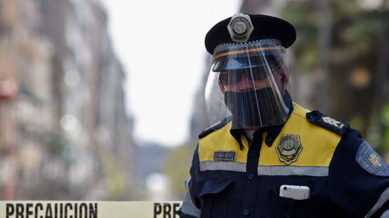 Un policía con mascarilla y escudo contra el contagio del nuevo coronavirus hace guardia en la plaza del Zócalo cerrada en Ciudad de México el 8 de abril de 2020. (ALFREDO ESTRELLA/AFP vía Getty Images)