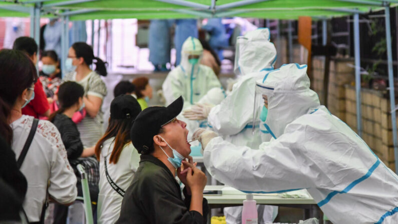 Un trabajador médico toma una muestra de hisopado a un residente para realizar la prueba del virus del PCCh en Wuhan, China, el 14 de mayo de 2020. (STR/AFP a través de Getty Images)