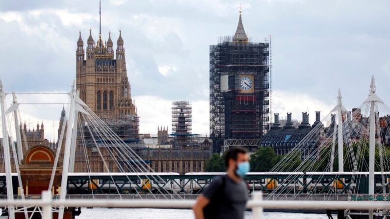 Un hombre con una mascarilla cruza el puente de Waterloo con el Palacio de Westminster detrás en el centro de Londres, Inglaterra, el 24 de agosto de 2020. (Tolga Akmen/AFP vía Getty Images)