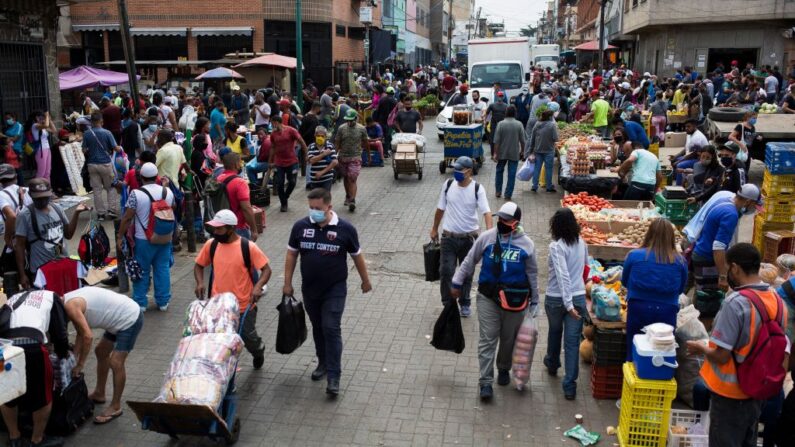 Personas con mascarillas caminan en un concurrido mercado callejero en el barrio de Catia, en Caracas (Venezuela), el 6 de abril de 2021. (Pedro Rances Mattey / AFP vía Getty Images)
