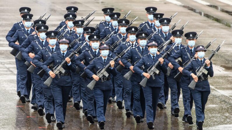 Policías realizan una nueva marcha de paso de ganso, el mismo estilo utilizado por la policía y las tropas en la China continental, en la escuela de policía de la ciudad durante una jornada de puertas abiertas para conmemorar el Día de la Educación en Seguridad Nacional en Hong Kong el 15 de abril de 2021. (ANTHONY WALLACE/AFP vía Getty Images)