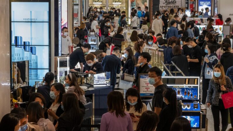 Los compradores y los empleados se ven en una tienda de cosméticos en un centro comercial en Beijing, China, el 18 de abril de 2021. (Kevin Frayer/Getty Images)