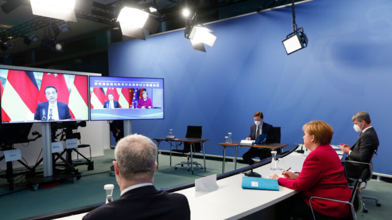 La canciller alemana, Angela Merkel, asiste a conversaciones virtuales con el primer ministro chino Li Keqiang (en la pantalla) el 28 de abril de 2021, en Berlín, Alemania. (Michele Tantussi-Pool/Getty Images)