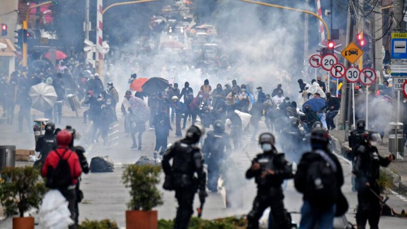 Manifestantes chocan con la policía antidisturbios durante una protesta contra un proyecto de ley de reforma tributaria frente a la casa del presidente colombiano Iván Duque en Bogotá el 1 de mayo de 2021. (Juan Barreto/AFP vía Getty Images)